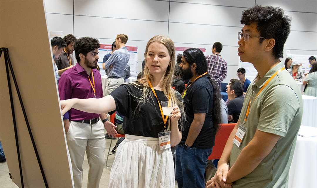 Photo of a student sharing research on a poster with another student at the CyLab Partners Conference