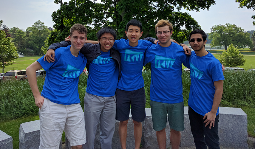 5 students posing outside, wearing matching shirts