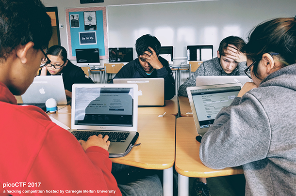 5 students on laptops working on picoCTF in classroom