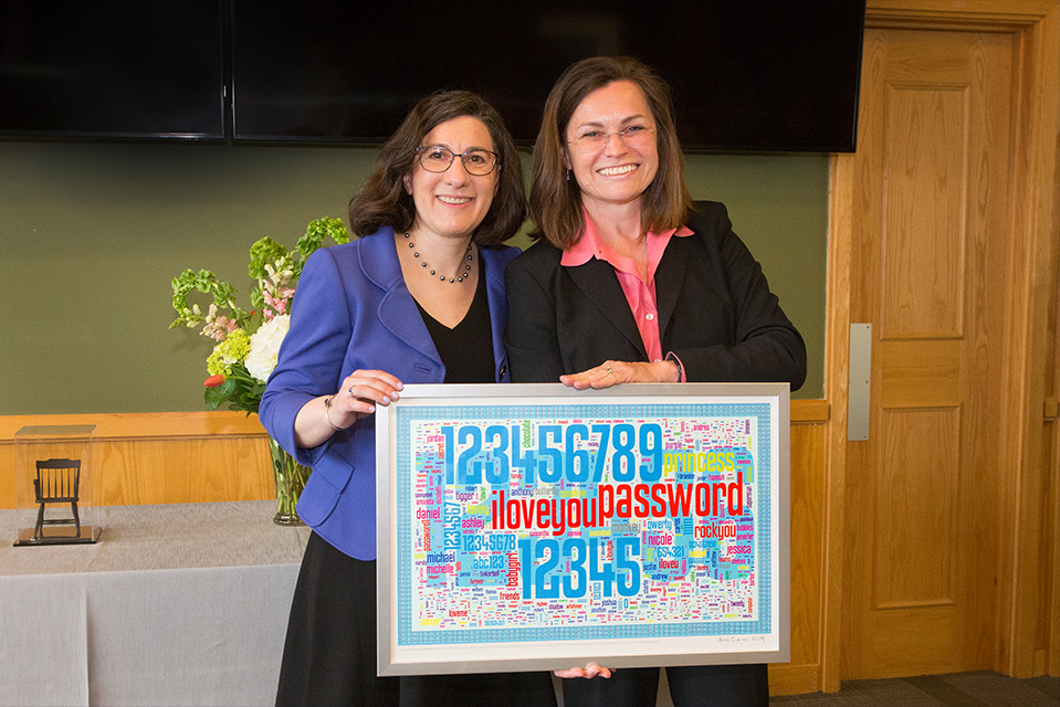 Cranor and Carnegie Bosch Institute president Sylvia Vogt pose with a framed print of Cranor's "Passwords Quilt," which Cranor gave to Bosch as a sign of appreciation for the endowed professorship.