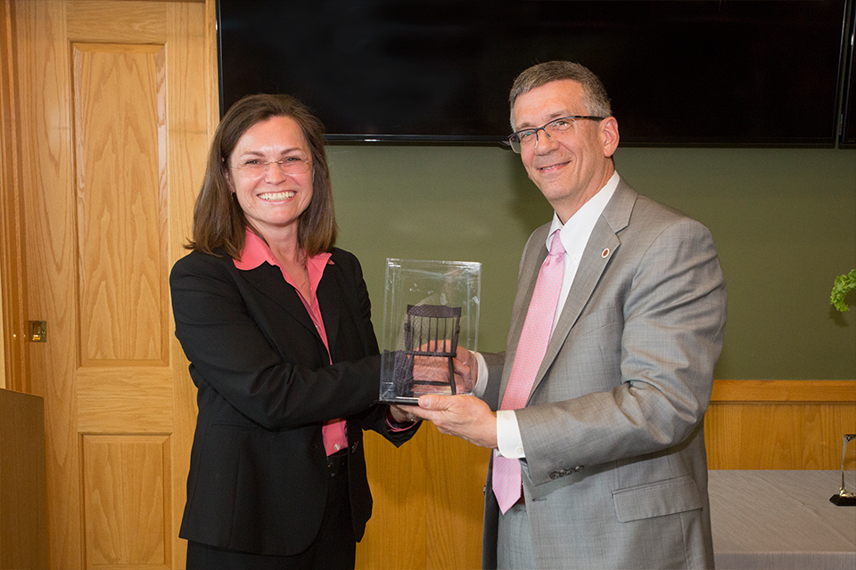 University provost James Garrett and Carnegie Bosch Institute president Sylvia Vogt pose with the 3-D printed "Chair," a symbol of Cranor's new endowed professorship.