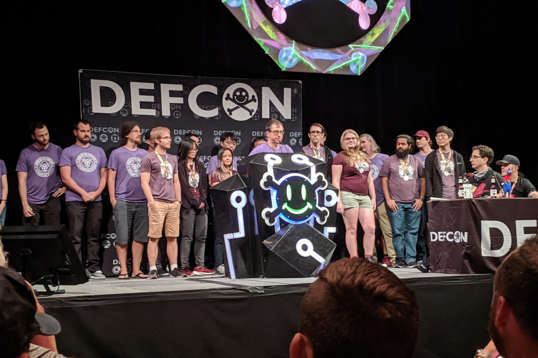 Group of students standing on a stage behind a male speaker