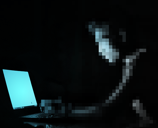 pixelated image of a person at a computer