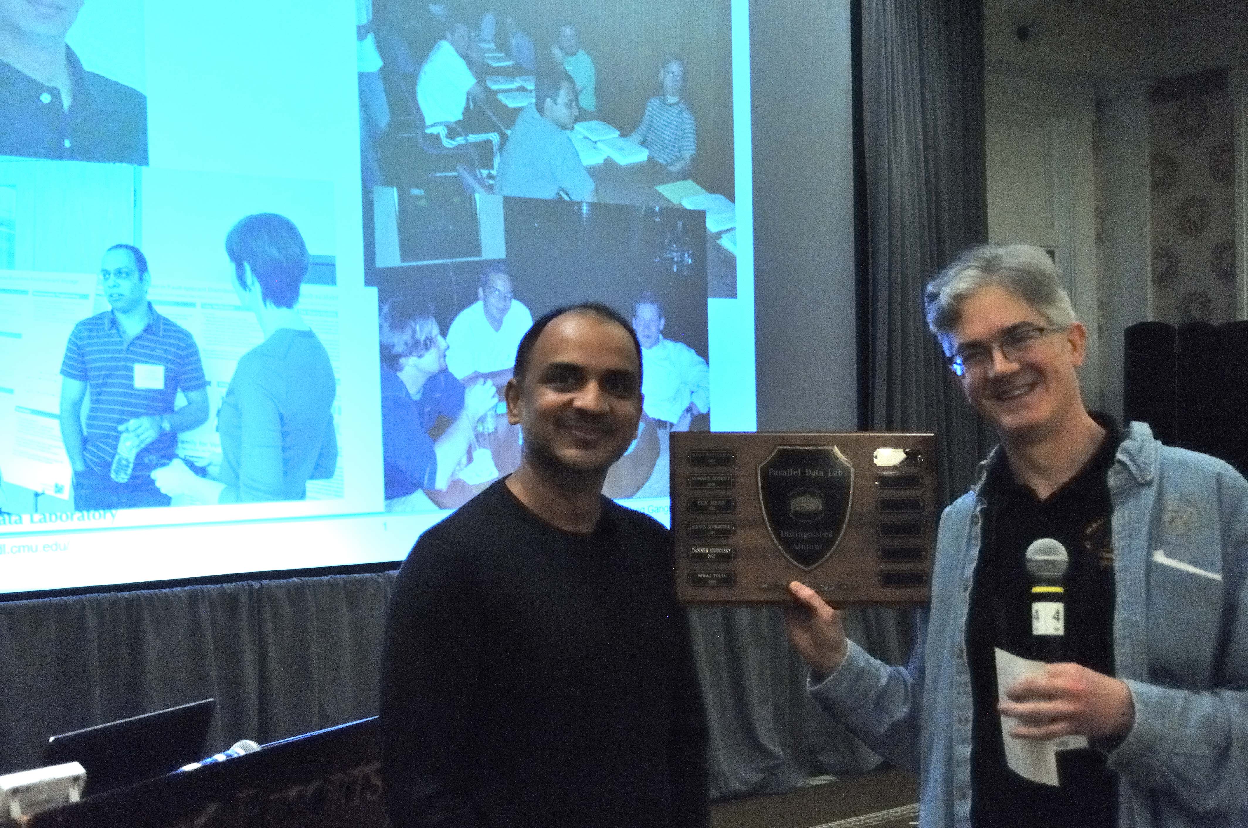 Photo of Niraj Tolia accepting the 2023 Parallel Data Lab (PDL) Distinguished Alumni Award from Greg Ganger, PDL director.