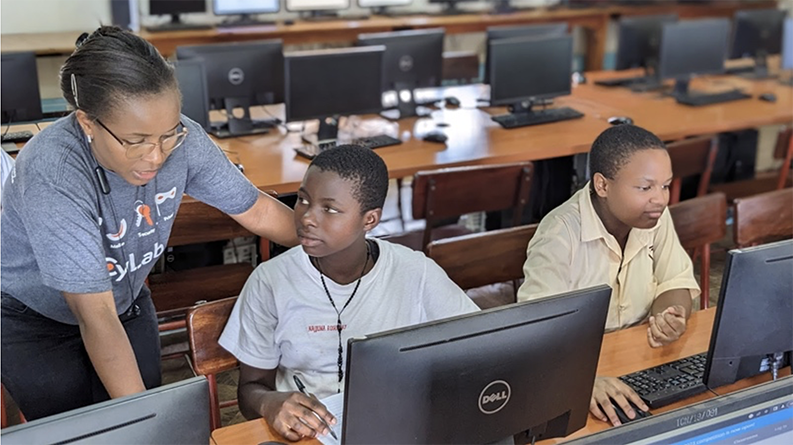 Photo of teacher helping students in a classroom