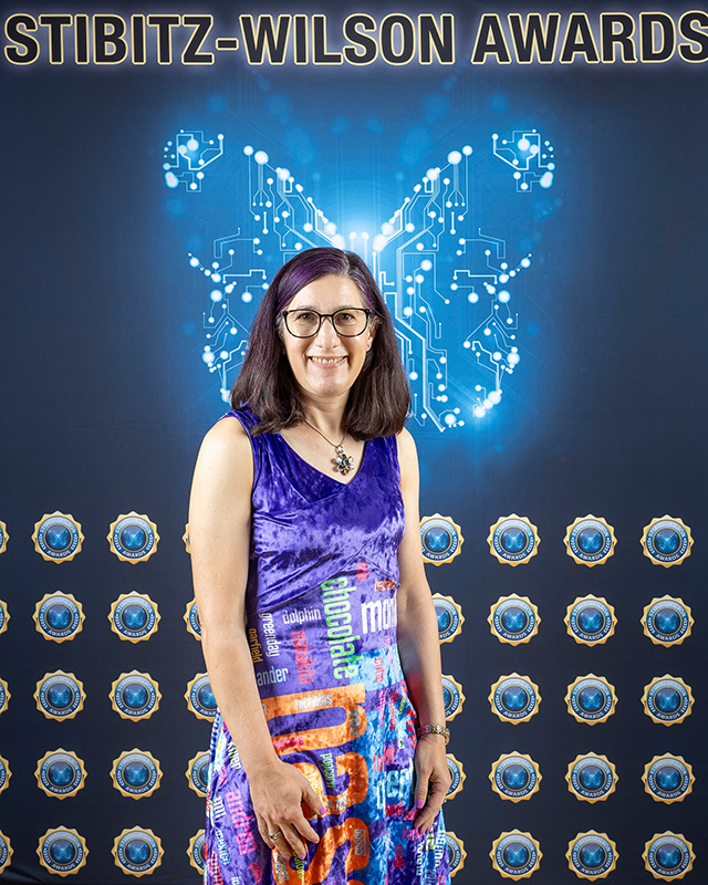 Image of Lorrie Cranor posing in front of a branded backdrop at the 2025 Stibitz-Wilson Awards