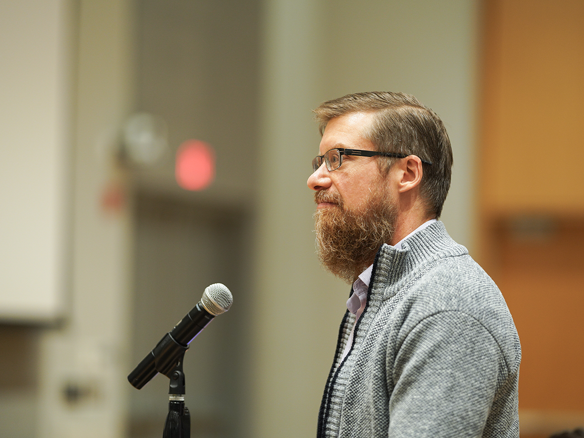 Photo of an attendee standing at a microphone asking a question to a speaker at the CyLab Partner's Conference