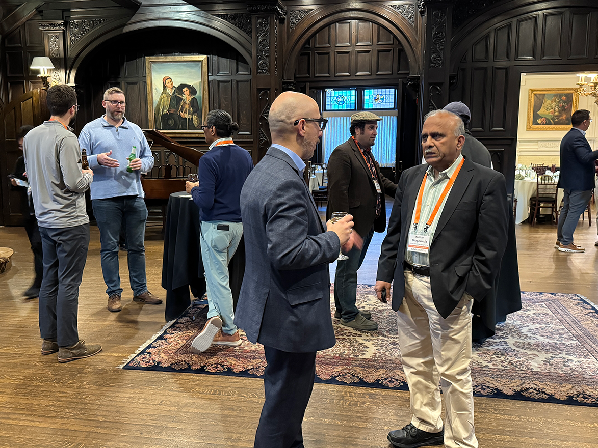 Photo of a group of people talking in the main hall at Mansions on Fifth