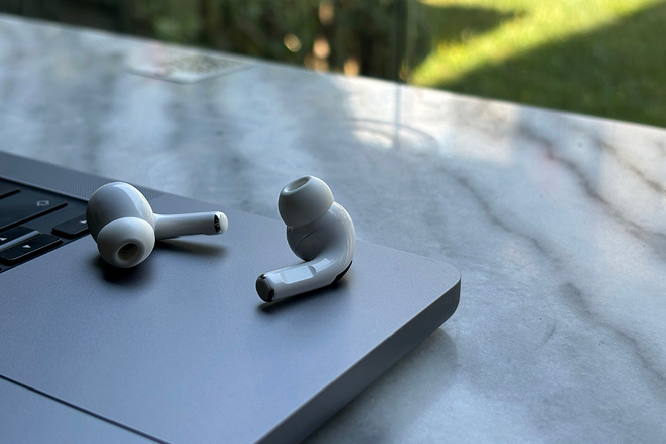 photo of earbud headphones lying on a table on an exterior patio
