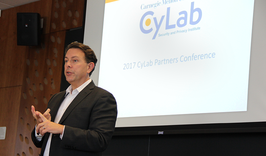 Doug Sicker speaking in front of projected CyLab logo